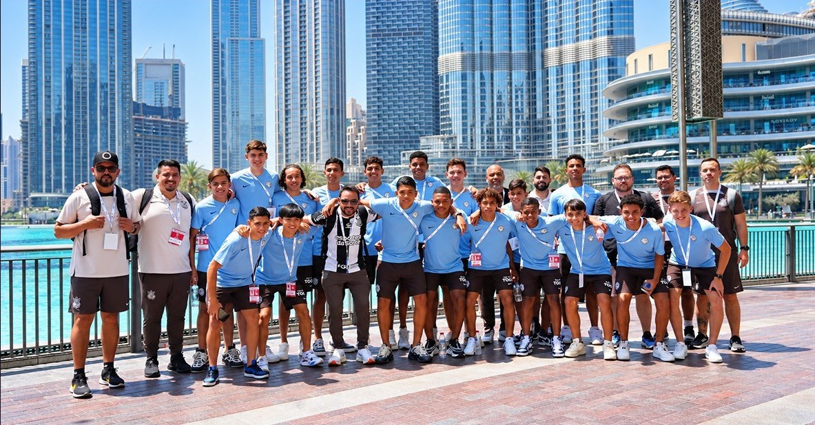 Youth football team and coaches gathered in front of the Dubai skyline
